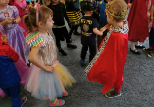 Dzieci w strojach karnawałowych tańczą obok siebie